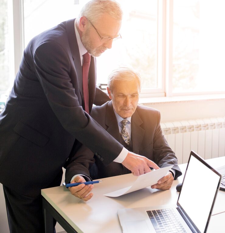 two-mature-businessman-discussing-business-project-office_23-2147923291