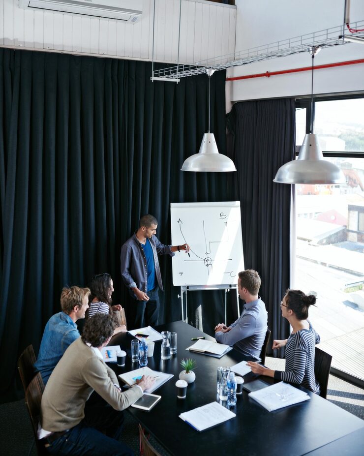 he-know-numbers-like-back-his-hand-shot-young-man-giving-presentation-whiteboard-colleagues-sitting-around-table-boardroom_590464-6982